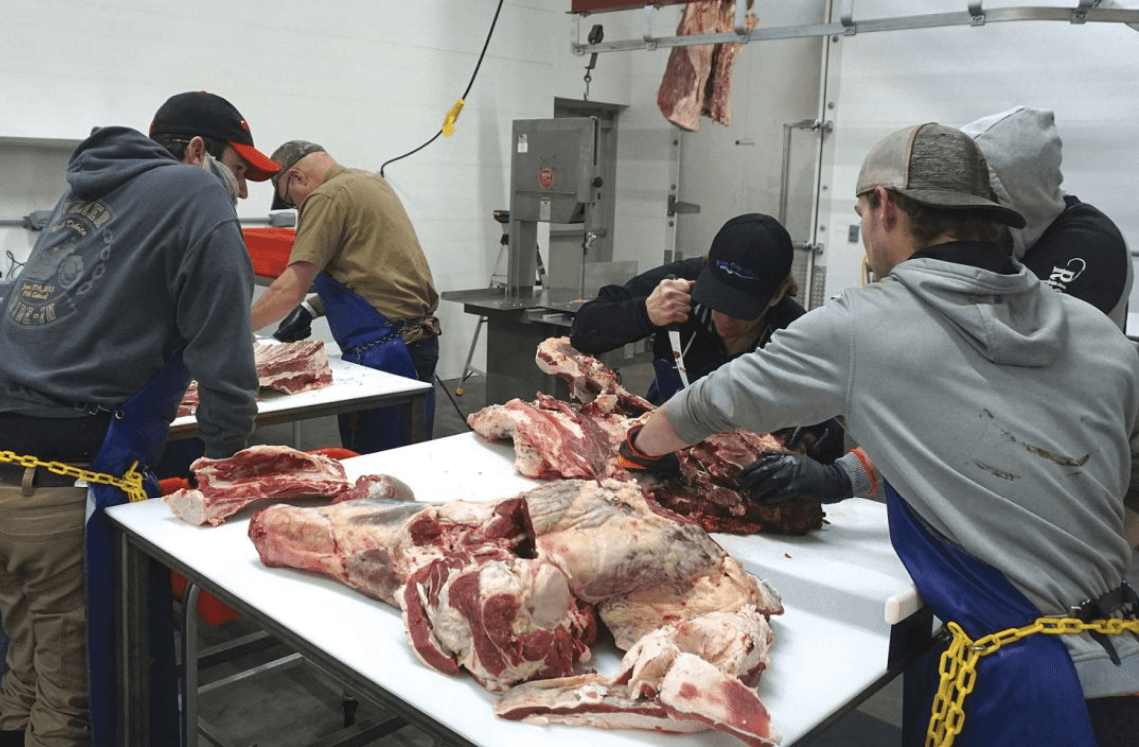 Mema's Meats staff processing beef on tables in the facility